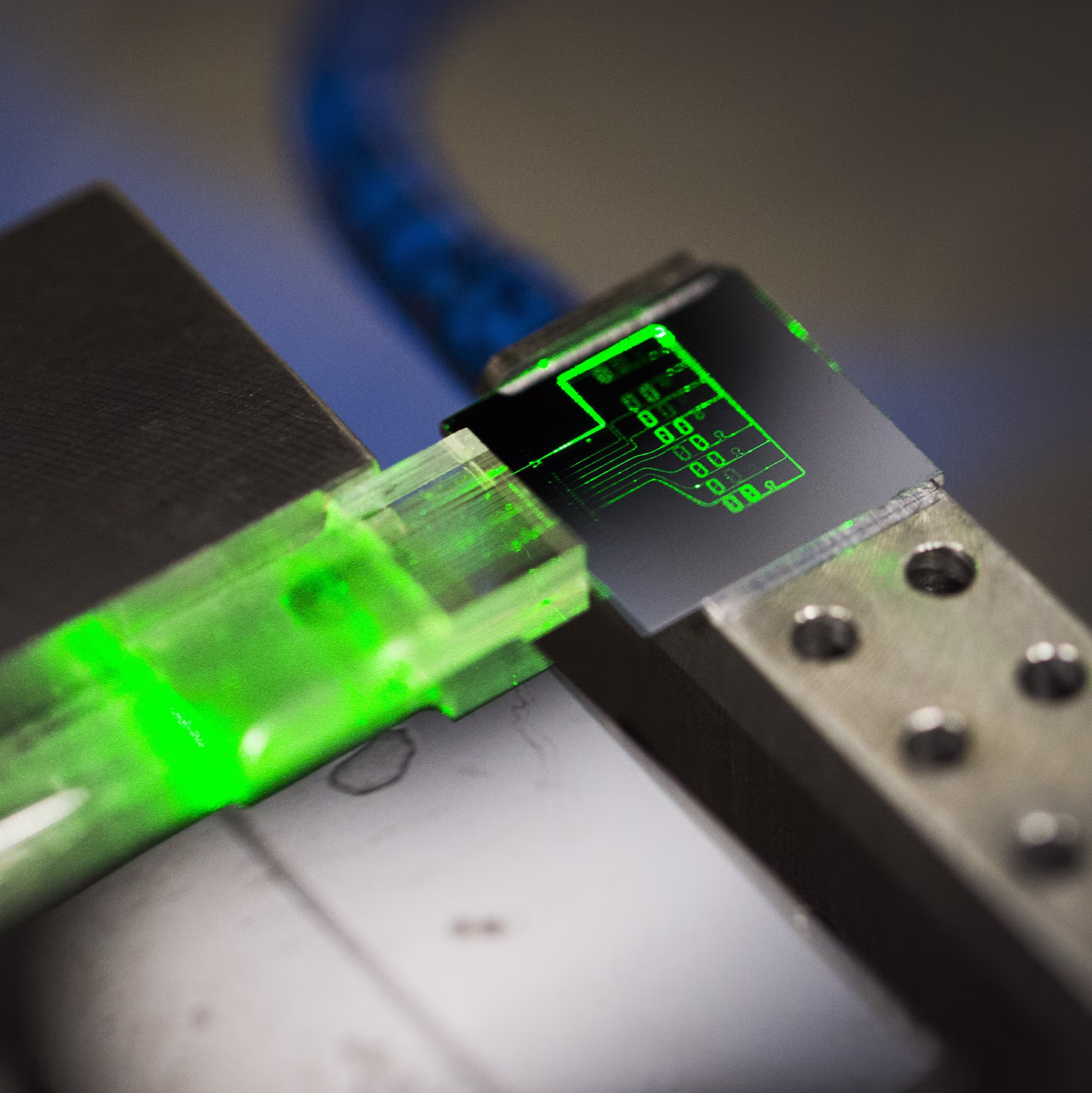 PhotonHub LioniX photonic biosensor chip illuminated green